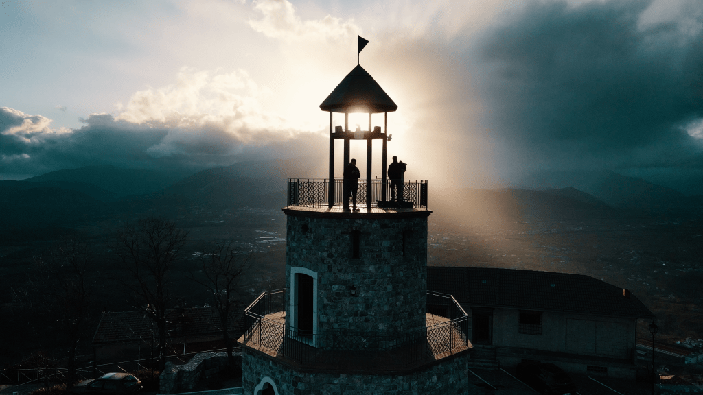 Ripresa di due piloti di droni durante il volo in Campania, con vista su un campanile