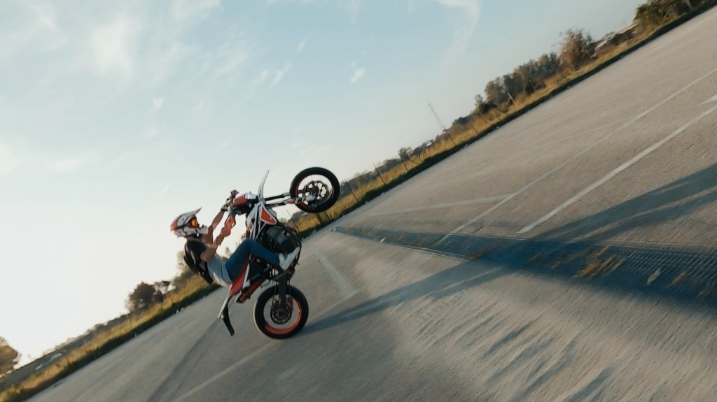 Ripresa con drone FPV di una moto che impenna in un parcheggio in Campania